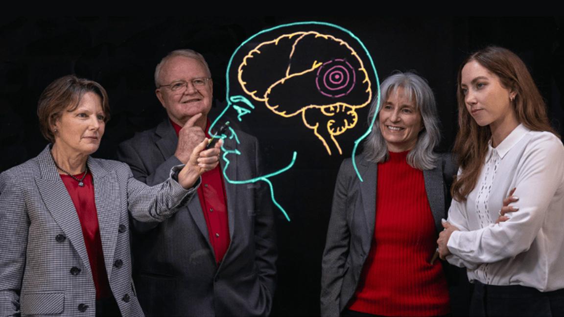 Four professors gesturing to brain image