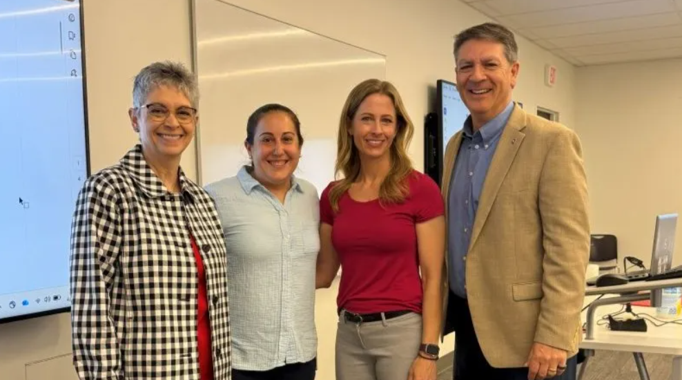 Jacyln Caccese standing with ERIK leadership's team who surprised her with the 2026 early career distinguished scholar award
